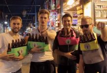 Toeristen spelen Simarik op bierflesjes in Kruidenbazaar